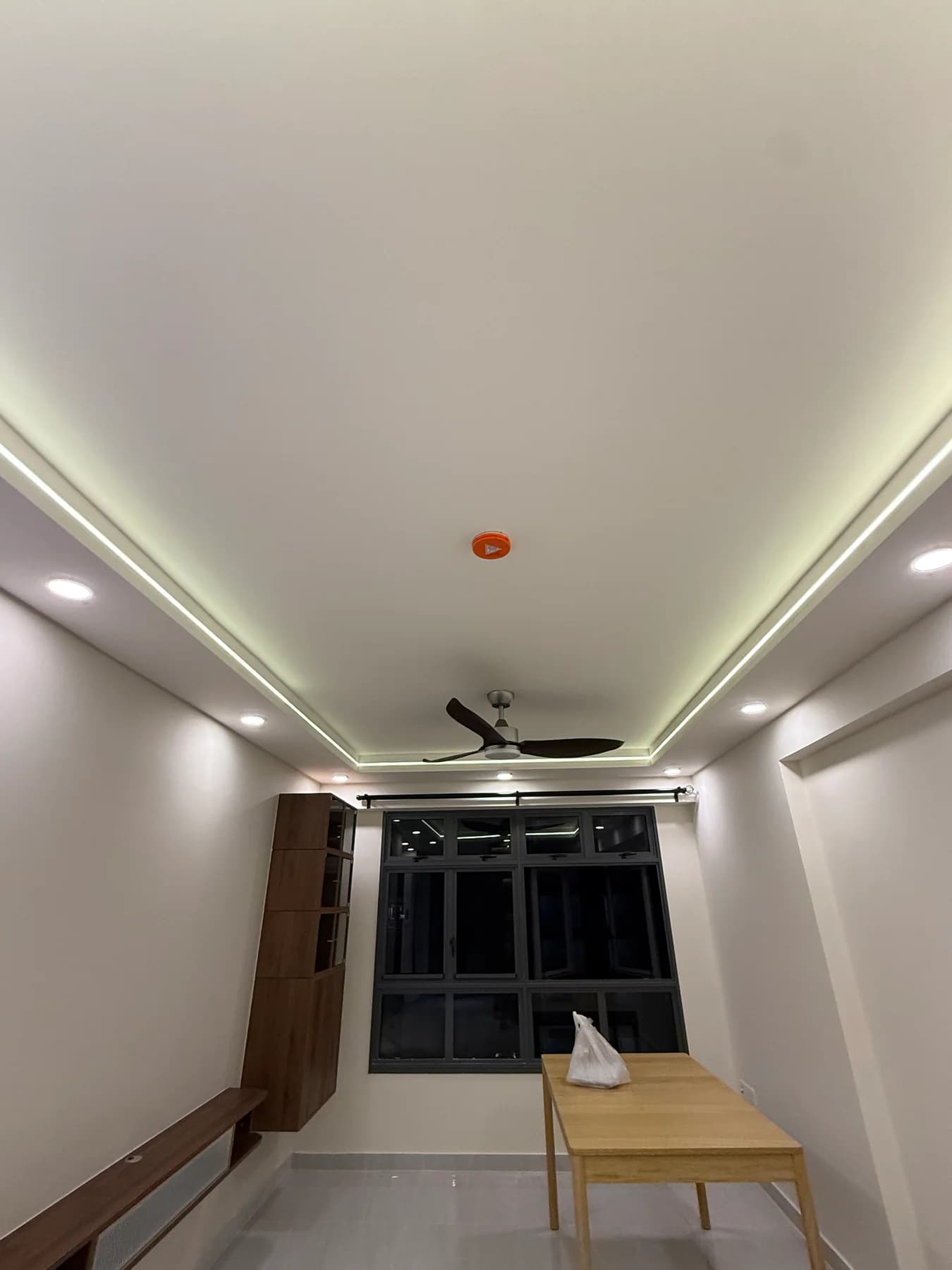Living area with tiled flooring, L-box ceiling, cove lighting and downlights