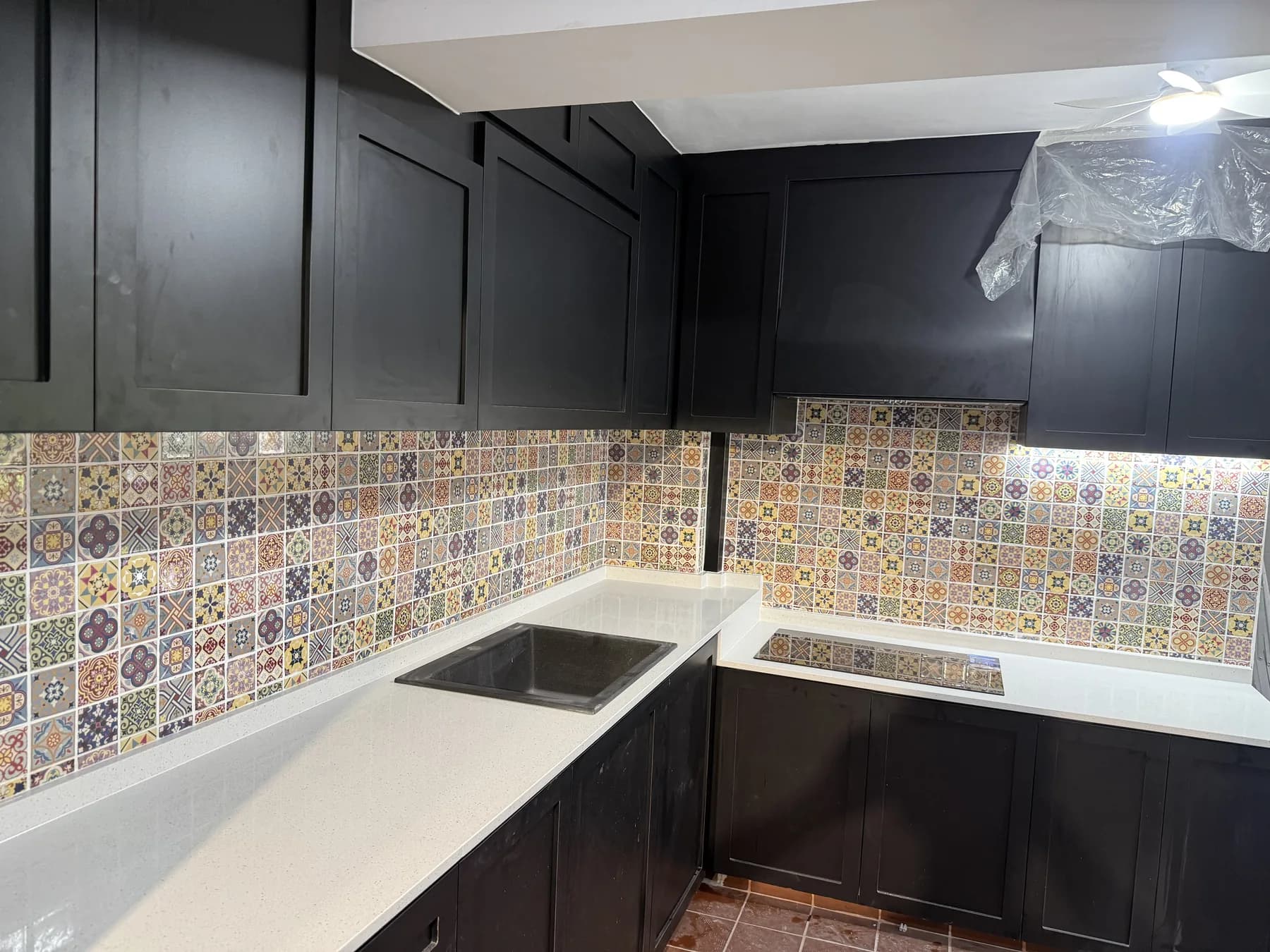 Completed black shaker-style kitchen with patterned backsplash at the Teban Gardens HDB