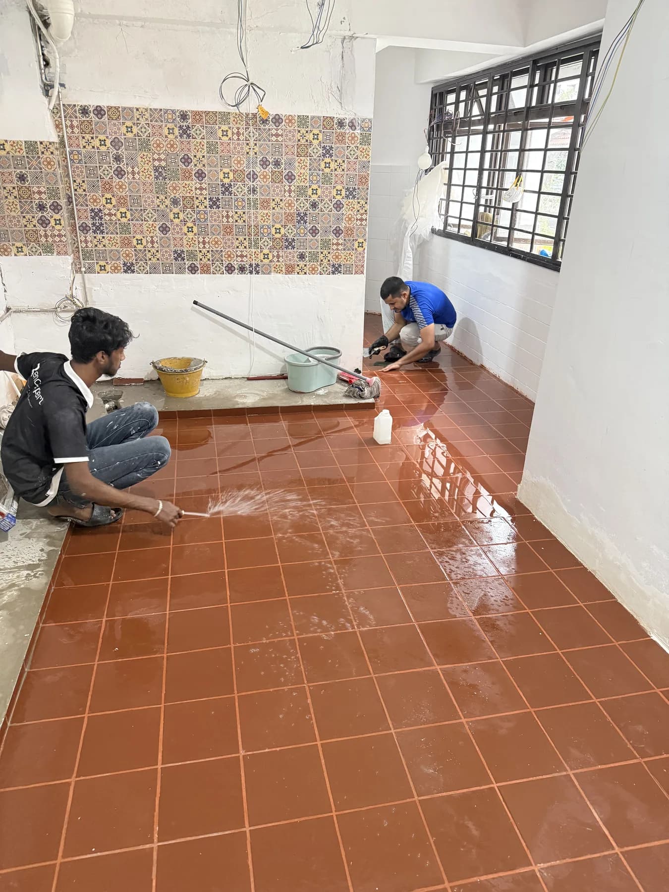 Terracotta-toned kitchen floor tiling in progress