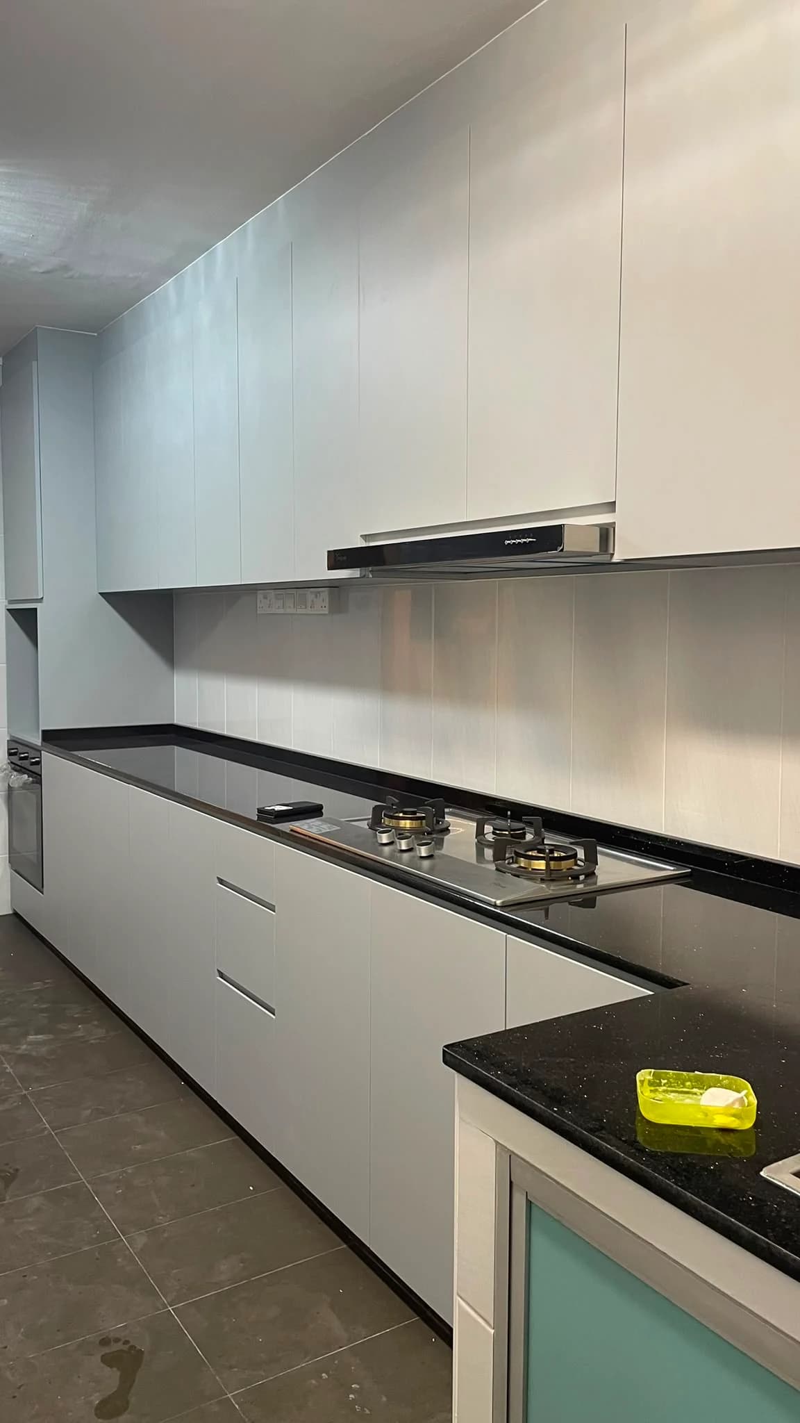White kitchen cabinets, hob and dark quartz countertop
