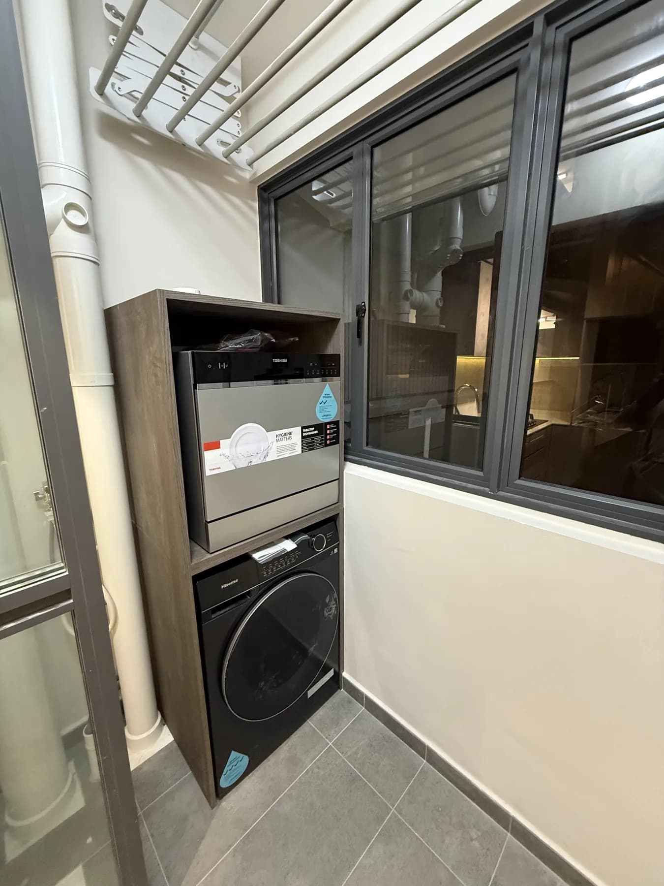 Custom washing-machine cabinet beside a casement window in the Bartley BTO service yard